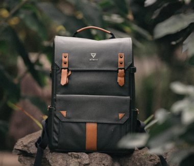 HEAVY-DUTY HIKING BACKPACK WITH ORANGE STRAPS IN A DARK FOREST